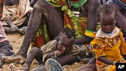 Turkana women and their children wait to receive relief food supplies near the Kakuma Refugee Camp, Turkana District, northwest of Kenya's capital Nairobi