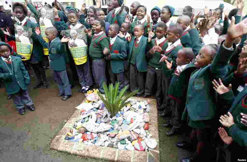 School children sing happy birthday to Mandela in front of his home in Houghton, Johannesburg, July 18, 2013.