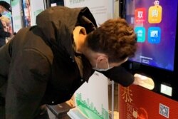 A man gets his movie ticket from an automated ticket machine at a cinema in Beijing, China, Feb. 19, 2021.