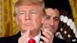 FILE - President Donald Trump applauds with House Speaker Paul Ryan of Wis., behind him in the East Room of the White House.