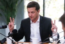 FILE - Ukrainian President Volodymyr Zelenskiy speaks with journalists in Kyiv, Ukraine, Oct. 10, 2019.