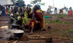 FILE - Congolese families, who fled from Democratic Republic of, prepare meals at United Nations High Commission for Refugees' (UNHCR) Kyangwali refugee settlement camp, Uganda, Mar. 19, 2018.