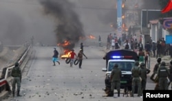 FILE - Protesters burn tires after Mozambique's ruling party, FRELIMO, retains power in contested election in Maputo, Oct. 24, 2024.