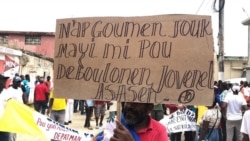 Protester in Port-de-Paix, Haiti holds sign that reads: "We'll fight until the corn gets ripe to untangle ourselves from killer Jovenel", during a protest to demand the president resign, Oct. 4, 2019. (Photo: Lucson Palmeus / VOA Creole)