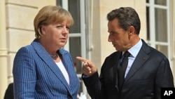 France's President Nicolas Sarkozy welcomes German Chancellor Angela Merkel as she arrives for a meeting at the Elysee Palace in Paris, August 16, 2011