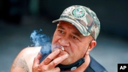 FILE - A man smokes in Auckland, New Zealand, Dec. 9, 2021. 