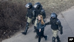 FILE - Police officers detain a demonstrator as they prevent an opposition action to protest the official presidential election results in Minsk, Belarus, March 27, 2021.
