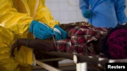 Medical staff take a blood sample from a suspected Ebola patient at the government hospital in Kenema, July 10, 2014. Ebola has killed more than 1,000 people across Guinea, Liberia and Sierra Leone since an outbreak began in February REUTERS/Tommy Trencha