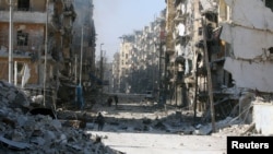 Syrians walk over rubble of damaged buildings, as they flee clashes between government forces and rebels in Tariq al-Bab and al-Sakhour neighborhoods of eastern Aleppo towards other rebel held besieged areas of Aleppo, Nov. 28, 2016.