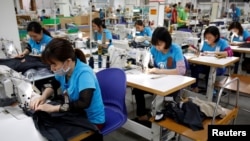 FILE - Women are seen working at Maxport, an export garment factory in Hanoi, Vietnam, March 20, 2019. 