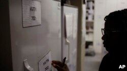 FILE - Pharmacist Mary Chindanyika labels a fridge containing a trial vaccine against HIV on the outskirts of Cape Town, South Africa, Nov. 30, 2016. The latest attempt in the long, frustrating search for a vaccine against HIV has begun in South Africa.
