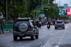 Anti-government protesters hold up three-finger salute in protest, Bangkok, 25 July 2021.(VOA/Tommy Walker)