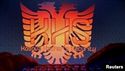 FILE - A man types on a keyboard in front of the logo of "Kosova Hackers Security" in a photo taken in Sarajevo, Bosnia, Oct. 16, 2015. Kosovo native Ardit Ferizi was found guilty in a U.S. court of providing the Islamic State group information on more than 1,000 U.S. government and military workers.