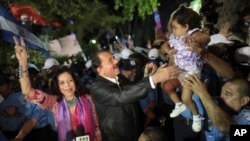 FILE.- In this Nov. 8, 2011 file photo Nicaragua's President Daniel Ortega, center, accompanied by his wife Rosario Murillo, left, greets supporters after delivering an address to the nation in Revolution Square in Managua, Nicaragua. First lady Rosario M