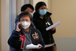 Workers at Queen Anne Healthcare, a skilled nursing and rehabilitation facility in Seattle, Washington, wait in a hallway to receive shots of the Pfizer vaccination for COVID-19, Jan. 8, 2021.