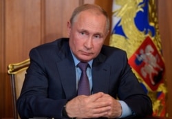 Russian President Vladimir Putin meets with two Russian businessmen in Sevastopol, Crimea, Aug. 13, 2019.