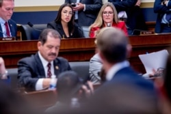Rep. Alexandria Ocasio-Cortez, D-N.Y., top center, questions Facebook CEO Mark Zuckerberg, foreground, as he appears before a House Financial Services Committee hearing on Capitol Hill in Washington, Oct. 23, 2019.