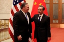 U.S. Secretary of State Mike Pompeo chats with Chinese Foreign Minister Wang Yi before their meeting at the Great Hall of the People in Beijing, China, June 14, 2018.