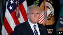 President Donald Trump listens as Treasury Secretary Steve Mnuchin speaks at the Treasury Department in Washington, April 21, 2017. 
