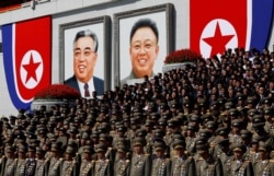 FILE - Senior military officials watch a parade as portraits of the late North Korean leaders Kim Il Sung and Kim Jong Il are seen at the main Kim Il Sung square in Pyongyang.