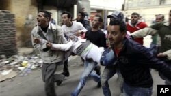 Egyptians carry an injured protester during clashes with anti-riot police in Cairo, Egypt, Saturday, Jan. 29, 2011.