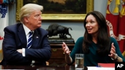 FILE - President Donald Trump, looks to Brooke Rollins, then-president and CEO of the Texas Public Policy Foundation, as she speaks during a prison reform roundtable in the Roosevelt Room of the Washington, Jan. 11, 2018. 