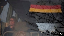 A stranded German tourist sits inside a bus taking her to the airport in Kathmandu, Nepal, March 27, 2020.