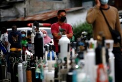 A man wearing a protective mask queues to refill oxygen tanks as Indonesia experiences an oxygen supply shortage amid a surge of coronavirus cases, at a filling station in Jakarta, Indonesia, July 5, 2021.