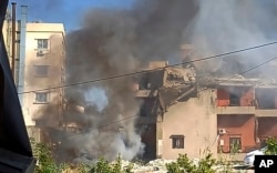 Smoke rises from a building hit by an Israeli airstrike, in the southern port city of Sidon, Lebanon, Oct. 27, 2024.
