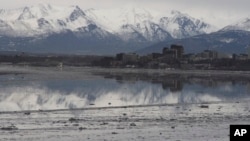 FILE- In this Feb. 12, 2016, photo, the Chugach Mountains and the buildings of downtown Anchorage, Alaska, are reflected in the still waters of Cook Inlet. Oil from an underwater pipeline leak was discovered in the inlet, April 1, 2017.