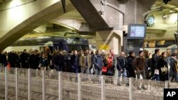 Commuters leave a train at the Montparnasse train station, Dec.17, 2019 in Paris on the 13th straight day of traffic headaches. 