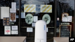 A hand sanitizer dispenser sits outside a food market in central Christchurch, New Zealand, Monday, May 11, 2020.