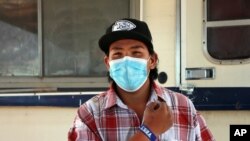 In this Oct. 19, 2020 photo, Cuba High School senior Cyliss Castillo shows off his slap bracelet USB drive loaded with assignments that was delivered by school bus driver Kelly Maeastas, outside Cuba, New Mexico. 