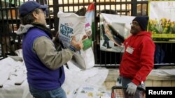 FILE - Employee Michael Torney (R) watches a customer carry out a bag of ice melt at Strosniders Hardware store in Silver Spring, Maryland, Jan. 21, 2016.
