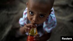 A migrant girl looks on at a village near the Thai-Myanmar border in Mae Sot, Thailand, Jan. 7, 2022.