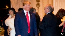 FILE - President Donald Trump speaks to attorney Alan Dershowitz, right, as he arrives for Christmas Eve dinner at Mar-a-lago in Palm Beach, Florida, Dec. 24, 2019. 
