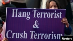 FILE - A child supporter of political party Pakistan Awami Tehreek (PAT), hold sign with others to condemn the attack by Taliban gunmen on the Army Public School in Peshawar, during a rally in Lahore, Dec. 21, 2014. 