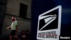 A man walks by a United States Postal Service mailbox in downtown Washington, Aug. 19, 2020. 