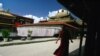 FILE - A Tibetan monk walks along the halls of the Jokhang Buddhist temple in Lhasa, Tibet.