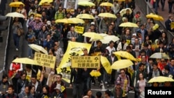 FILE - Protesters carrying yellow umbrellas, the symbol of the Occupy movement, march on a street in Hong Kong, Feb. 1, 2015. 