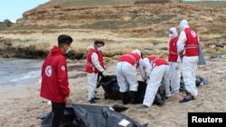 Para petugas Bulan Sabit Merah melakukan evakuasi para korban, pasca tenggelamnya perahu migran di lepas pantai Qassr Alkhyar, Libya.