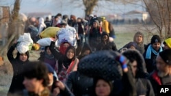 Migrants walk to reach Pazarakule border gate, Edirne, Turkey, at the Turkish-Greek border on Sunday, March 1, 2020. 