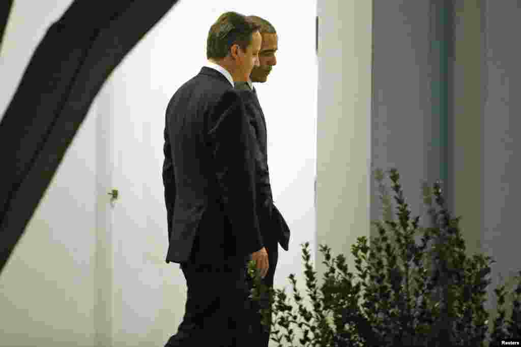 U.S. President Barack Obama escorts Britain's Prime Minister David Cameron to a working dinner at the White House in Washington, Jan. 15, 2015.