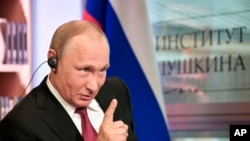In this Monday, May 29, 2017 photo released by the Sputnik news agency, Russian President Vladimir Putin speaks during an interview in Paris, France. 