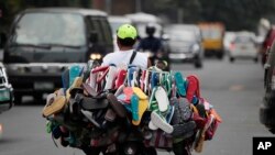 A man sells rubber flip-flops on his motorcycle in Manila, Philippines, 2013. (AP Photo/Aaron Favila)