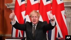 Britain's Prime Minister Boris Johnson gives a thumbs-up gesture after signing the EU-UK Trade and Cooperation Agreement at 10 Downing Street, London, Dec. 30, 2020. 