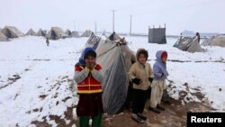 Anak-anak pengungsi Afghanistan berdiri di depan tenda mereka di kamp penampungan pengungsi di pinggiran kota Herat, 20 Januari 2015 (Foto: dok/ REUTERS/ Mohammad Shoib)