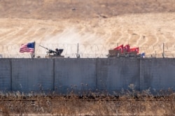 FILE - U.S. and Turkish armored vehicles take part in their first joint patrol with Turkey under a deal reached between Washington and Ankara, at the border with Syria near Akcakale, in the Sanliurfa province of Turkey, Sept. 8, 2019.