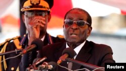 Zimbabwean President Robert Mugabe gestures as he addresses mourners gathered for the burial of Vice-President John Nkomo at National Heroes Acre, in Harare, Zimbabwe, January 21, 2013.