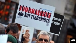 FILE - Turkish journalists gathered to protest against the jailing of opposition Cumhuriyet newspaper's editor-in-chief Can Dundar and Ankara representative Erdem Gul, in Istanbul, Dec. 26, 2015. 